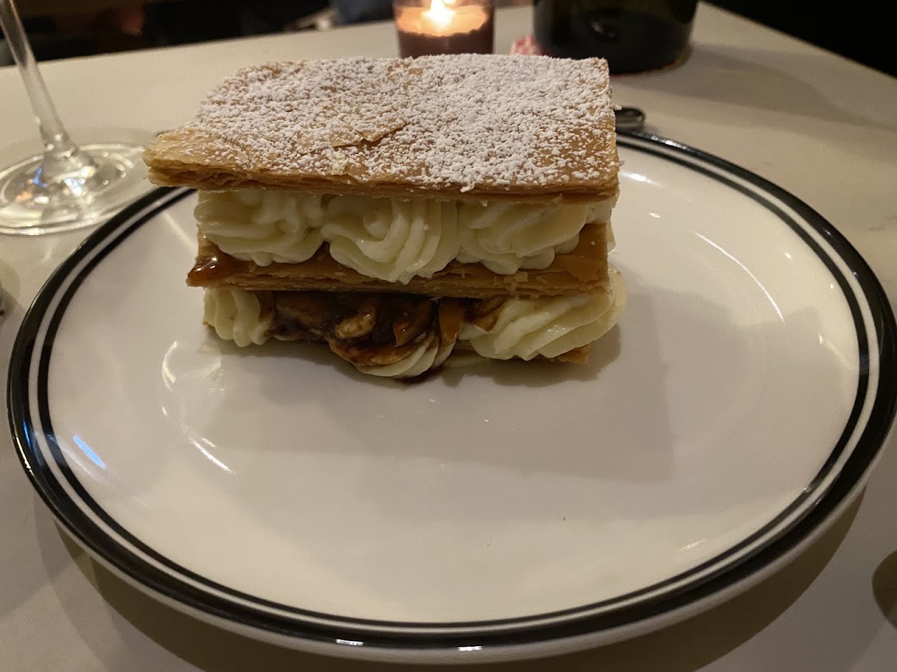 Layered dessert dusted with sugar on a plate